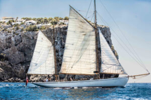 gaff ketch Owl sailing with cliff behind